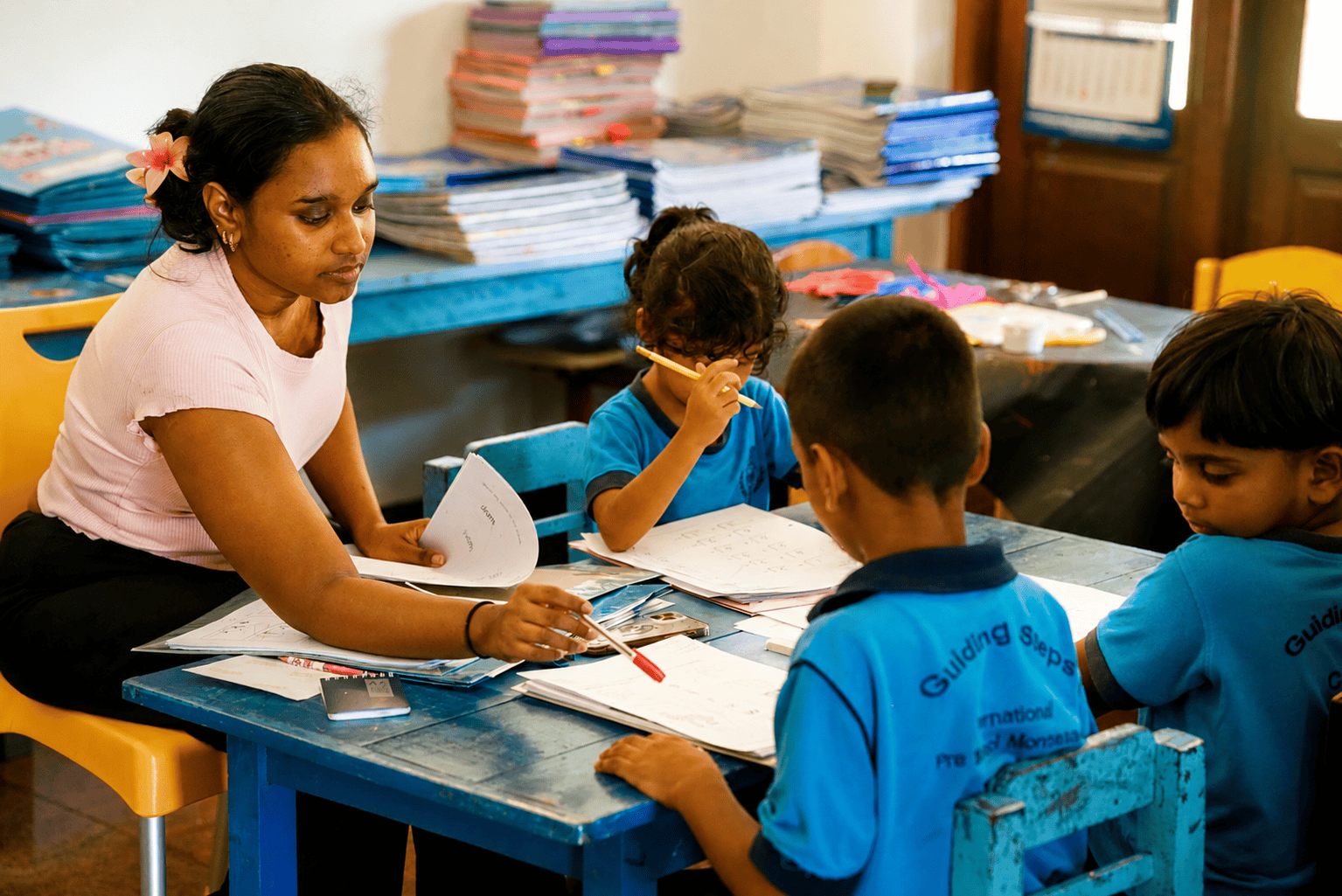 Teacher reviewing work with preschoolers at the activity table