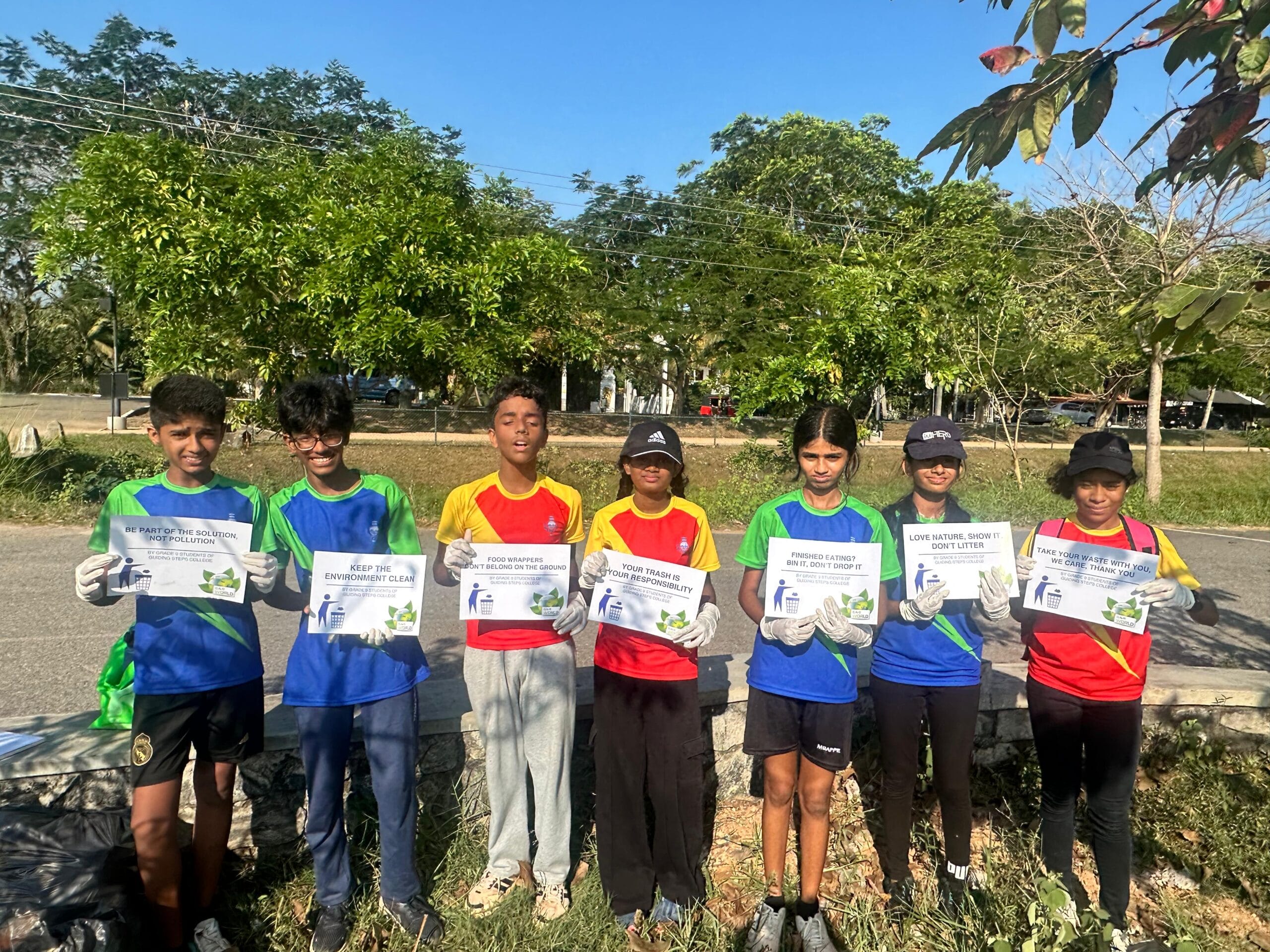 Students of Guiding Steps College holding anti-litter awareness posters at a community clean-up