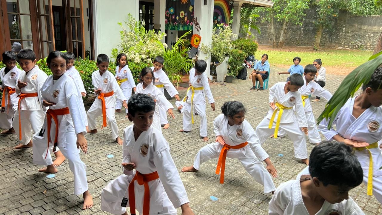 Young karate students practising fighting stances during an outdoor class at Guiding Steps College