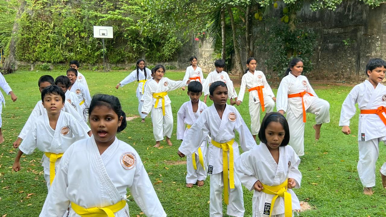 Karate class practising kicks and strikes on the school grounds at Guiding Steps College